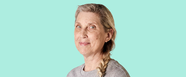 50+ year old woman smiling with yellow background
