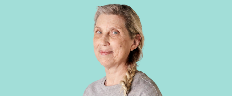 50+ year old woman smiling with yellow background