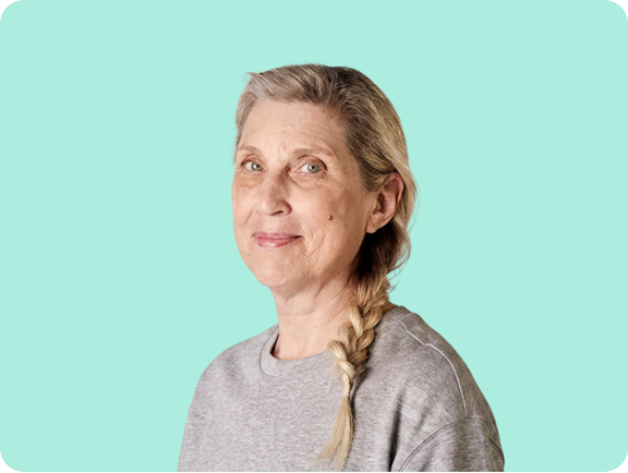 50+ year old woman smiling with yellow background