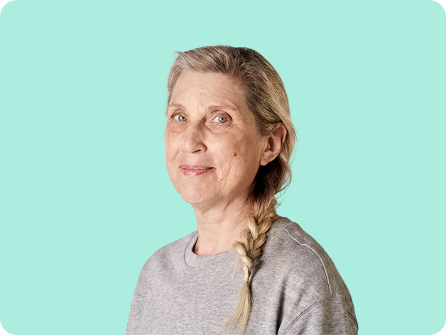 50+ year old woman smiling with yellow background